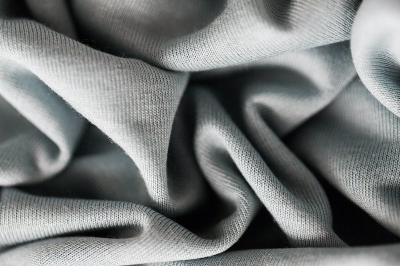 textile and texture concept - close up of crumpled gray cotton fabric background