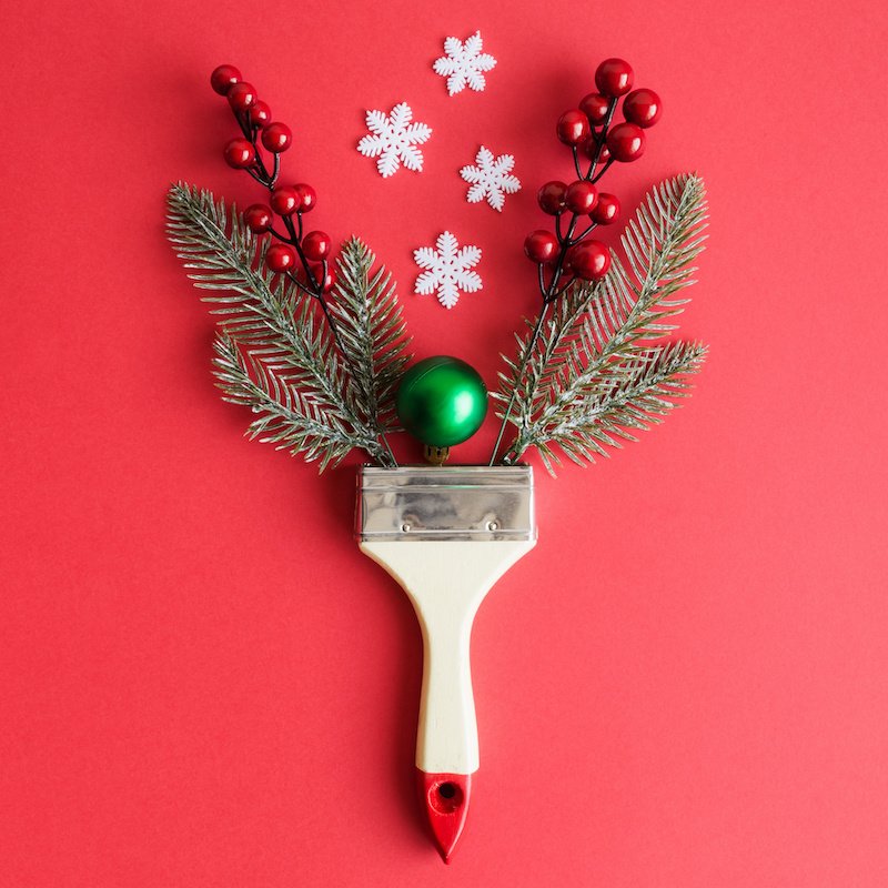 Paint brush with christmas decoration abstract on red background.