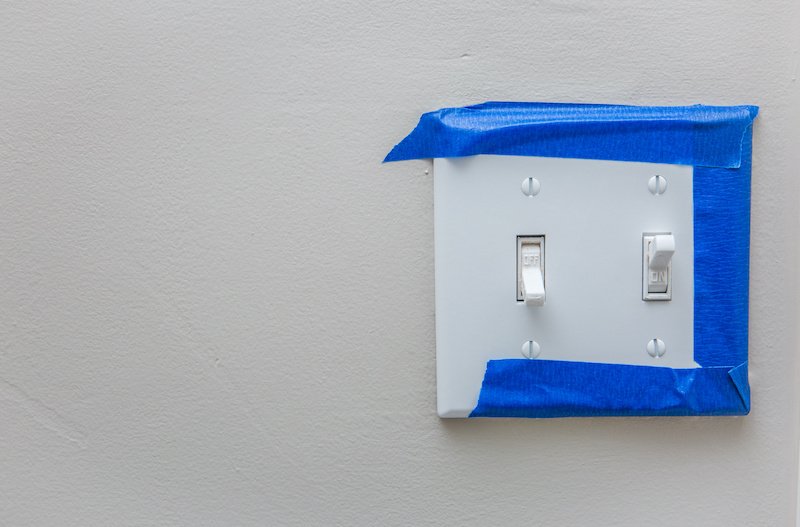 Light switch with blue painter's tape around it