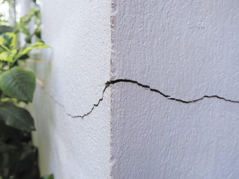 Cracked concrete building wall at the outside corner that effected with earthquake and collapsed ground for paint prep