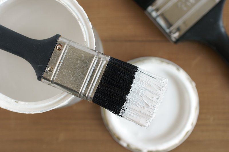 Painting and decorating shallow focus top down view of a pot of white paint and brush