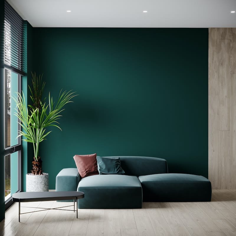 Livingroom mockup with a dark green sofa and emerald color walls. Empty space for a gallery and paintings, art. Painting the wall in a deep accent tone. Modern luxury design room. 3d rendering