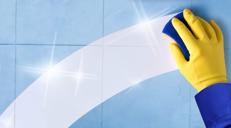 Concept of professional cleaning employee with blue tiles background and clean trace for paint prep