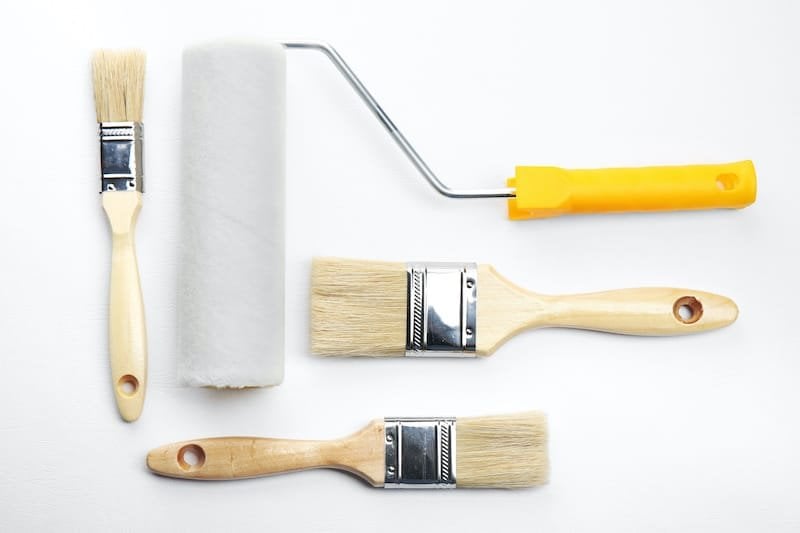 Paint roller and brushes on white textured background