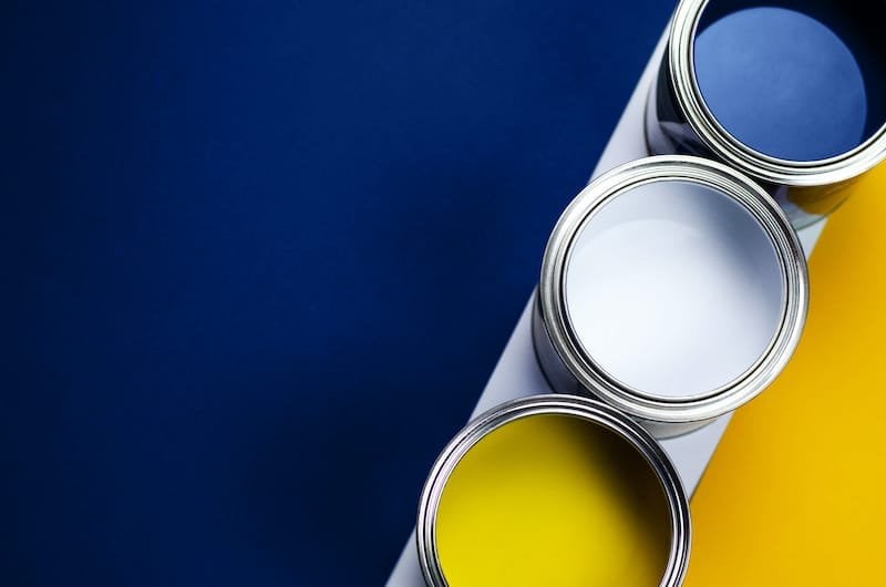 Cans of paint on a background of yellow and classic blue. Color of the year 2020. Main color trend concept. Paint Trends with contrast. 