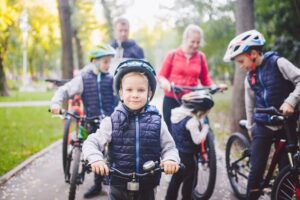 Theme family sports vacation in park in nature. big friendly Caucasian family of six people mountain bike riding in forest. Children brothers and sister stand on the background of parents in a row.