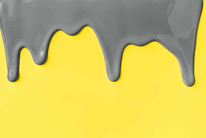 Gray paint leaking down yellow background. Colors 2021.