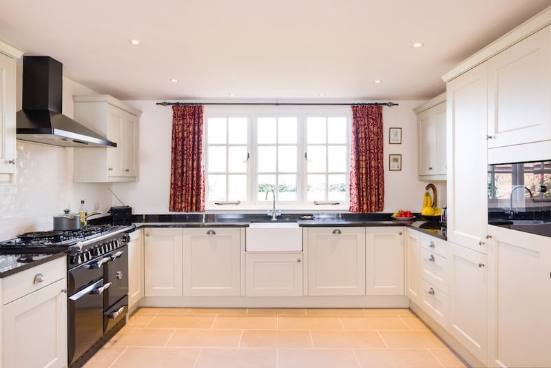 Shaker style farmhouse kitchen with neutral painted wood modular units, UK kitchen interior design