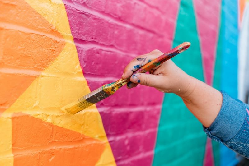 Artist painting on a brick wall