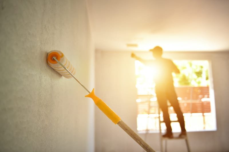 Engineer Construction painter man at work with a paint roller on the wall  In ASEAN