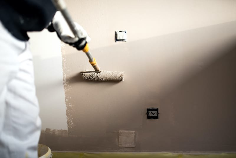 Professional Painting Handy man decorating walls with paint. Construction plaster worker painting and renovating with professional tools