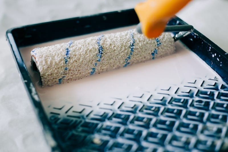 the roller is wetted in a liquid primer in a plastic black container