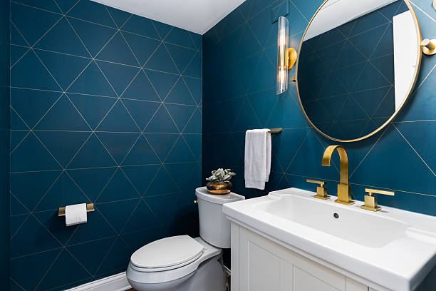 Bold navy bathroom accent wall paint paired with modern gold fixtures by a house painter in Nampa, ID