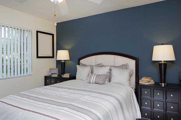 Bedroom with a deep blue accent wall and crisp white trim by a painting company in Mountain Home, ID.