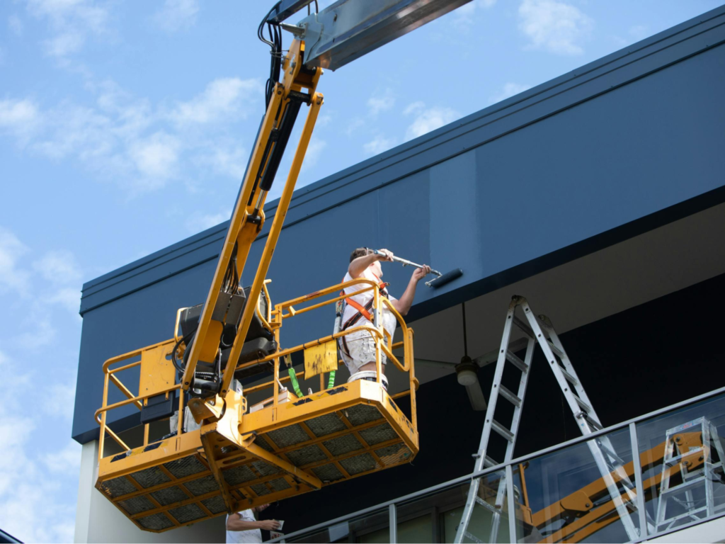 Professional painter applying exterior coating to a commercial building showcasing the expertise of a commercial painter in Star, ID.